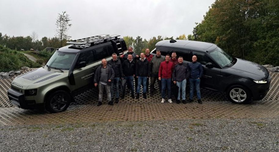 eismann- Mitarbeiter stehen vor 2 großen Range Rovern